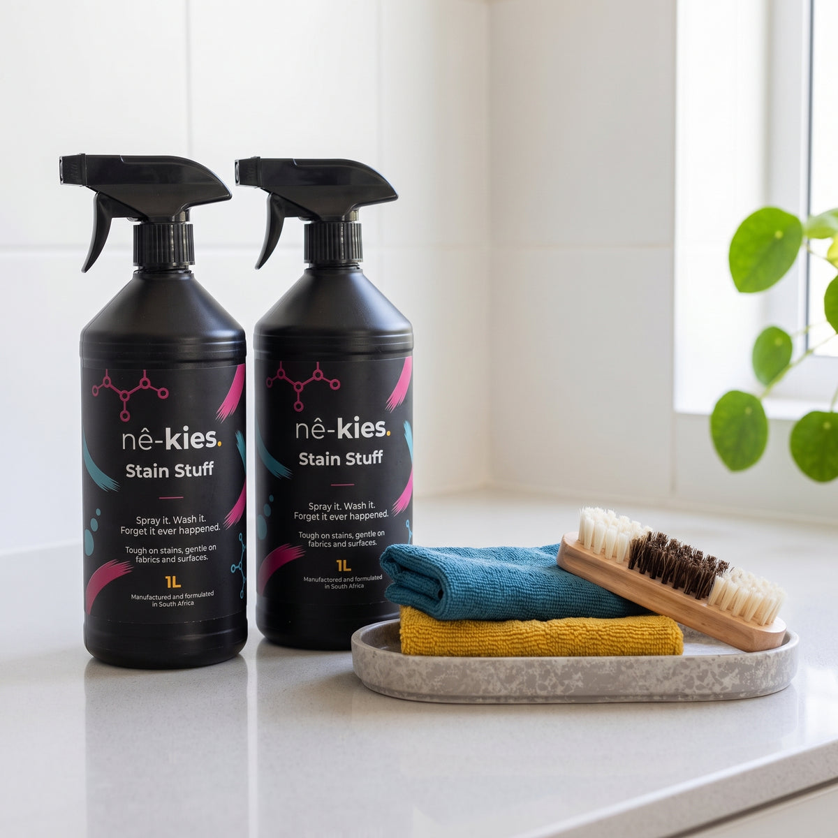Two bottles of Nê-Kies Stain stuff, two microfibre cloths and one wooden soft-bristle brush